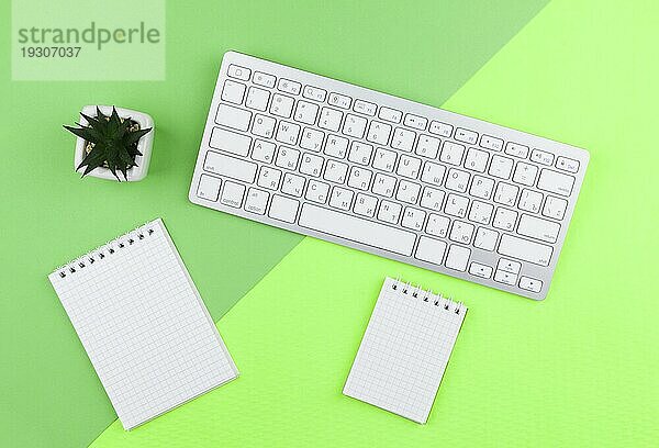 Draufsicht Schreibwarenanordnung grüner Hintergrund mit leeren Notizblöcken