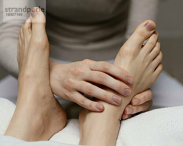 Nahaufnahme Therapeutin massiert Fuß