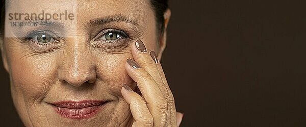 Lächelnde ältere Frau posiert mit Make up