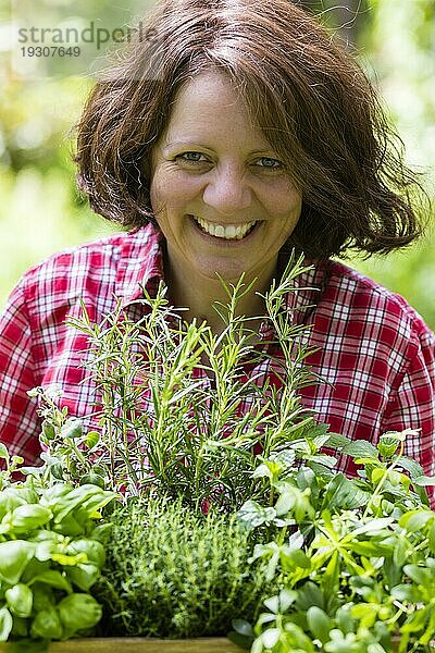 Junge Frau mit Kräutern im Garten  junge Frau mit Kräutern in einem Garten