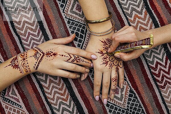 Künstler macht mehndi womans Hand hellen Tisch