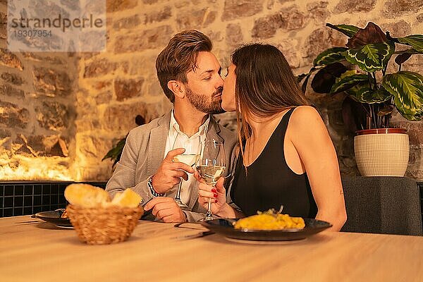 Lifestyle  ein junges  verliebtes Paar  das sich in einem Restaurant küsst und Spaß beim gemeinsamen Essen hat  um den Valentinstag zu feiern