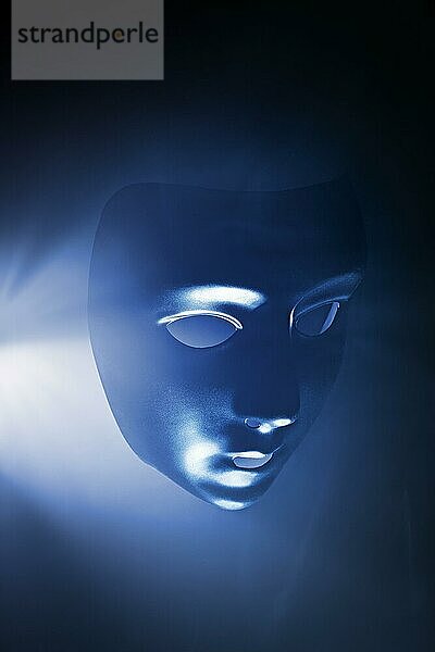 Leere Maske in blauem  dunstigem Licht. Kurze Tiefenschärfe