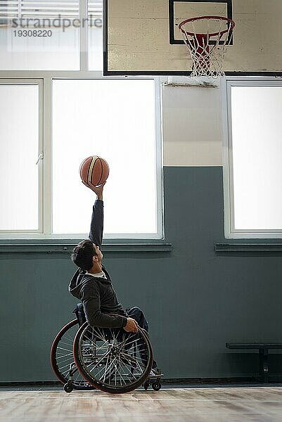 Vollbild Mann hält Basketball hoch