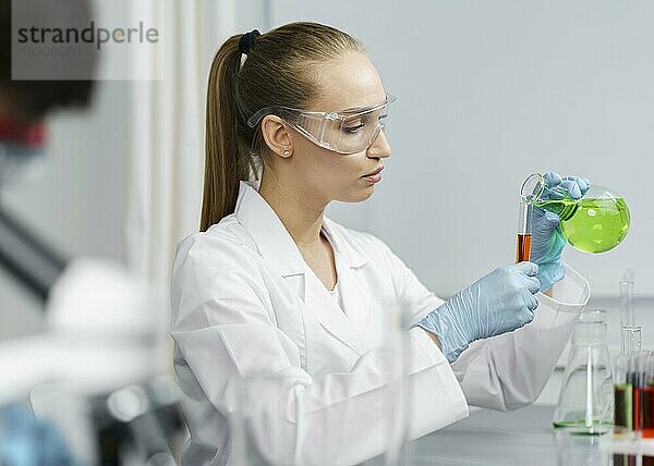 Seitenansicht weibliche Forscherin Labor mit Reagenzgläsern Schutzbrille