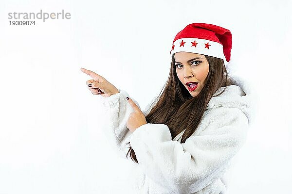 Brünettes Mädchen an Weihnachten mit weißem Hintergrund  mit Weihnachtsmütze mit Sternen  Porträt nach links zeigend  Kopierraum