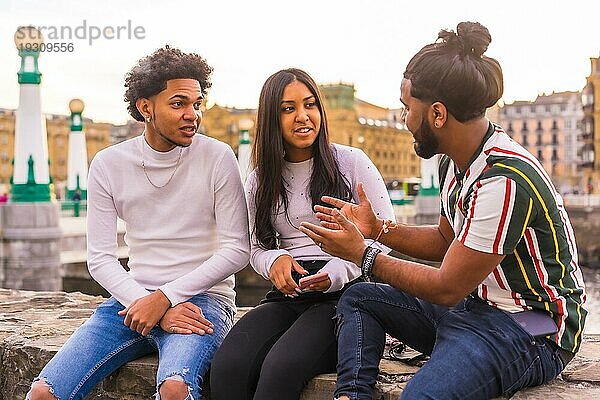 Lifestyle  drei schwarze Freunde haben Spaß in der Stadt mit dem Sonnenuntergang im Hintergrund  abnehmen und Millennial in der Stadt. Afro Haar Junge  Brünette Junge mit langen Haaren und Brünette Mädchen