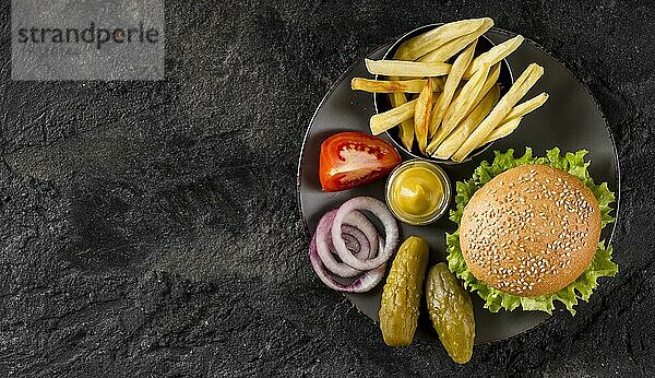 Draufsicht Burger Pommes Teller mit Essiggurken Kopierraum