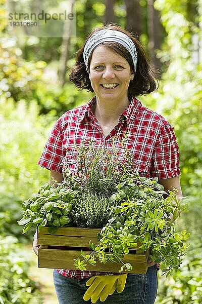 Junge Frau mit Kräutern im Garten  young woman with herbs in a garden