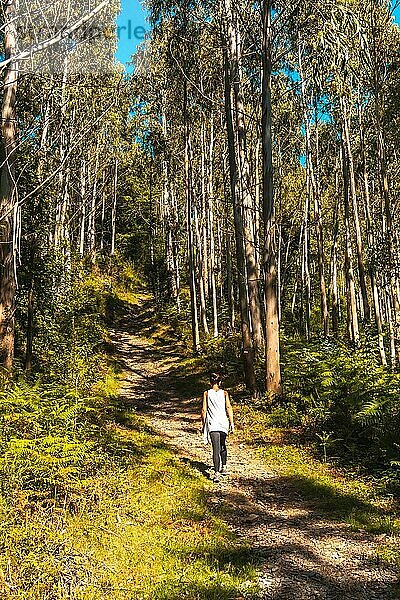 Eine junge Frau im weißen TShirt spaziert fröhlich durch den Naturpark Listorreta in der Gemeinde Errenteria im Park Peñas de Aya oder Aiako Harria. Gipuzkoa  Baskenland