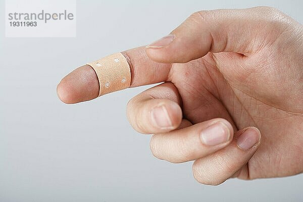 Ein Finger mit Textilklebeverband. Kurze Tiefenschärfe