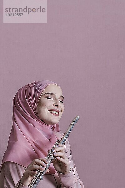 Muslimische Frau spielt Flöte