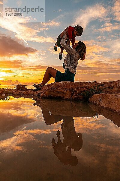 Sonnenuntergang auf Ibiza im Urlaub  eine Mutter mit ihrem Sohn hat Spaß am Meer in San Antonio Abad