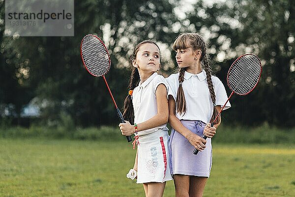 Verärgerte Mädchen halten Badminton Hand suchen sich gegenseitig