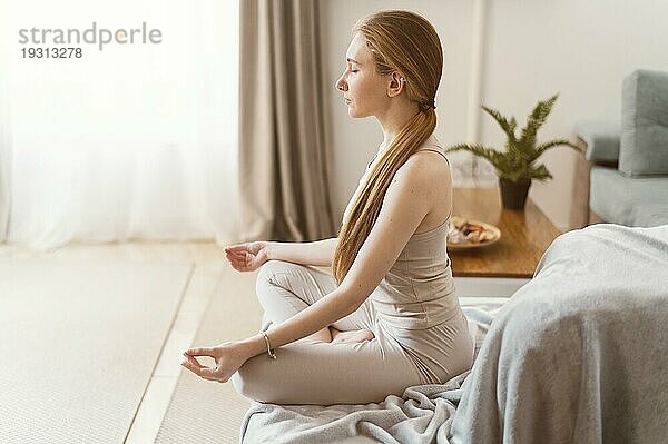 Seitenansicht junge Frau meditiert zu Hause