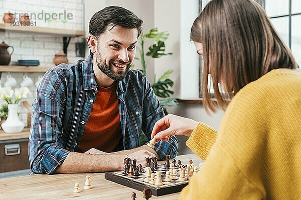 Junger Mann spielt Schach mit seiner Frau zu Hause