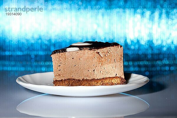 Leckerer Schokoladenkuchen auf leuchtend blauem Hintergrund. Unscharfer Fokus