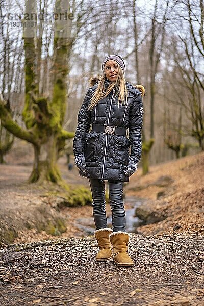 Sehr glückliches junges blondes Mädchen bei einem Fotoshooting in einem schönen Wald