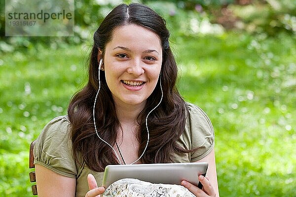 Junge Frau mit Tablet PC im Garten  young woman with tablet PC in a garden