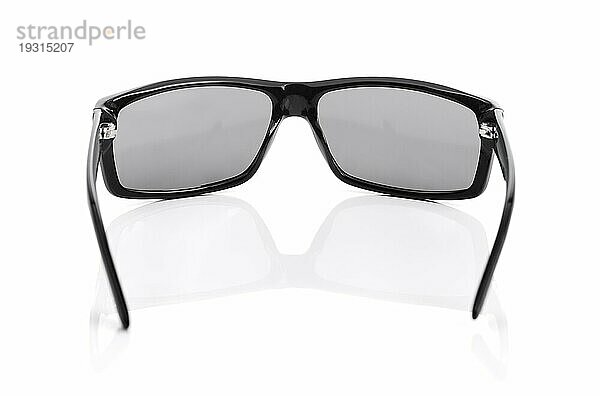 Eine hochwertige Sonnenbrille auf Weiß mit natürlicher Reflexion. Kurze Tiefenschärfe