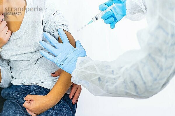 Eine Ärztin beruhigt das Kind zusammen mit seiner Mutter vor der Impfung. Impfung von Kindern. Impfung bei der Coronaviruspandemie Covid19