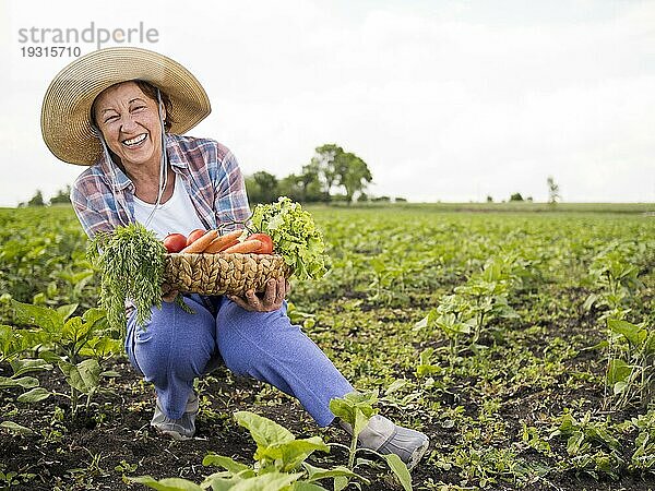 Frau hält Korb voller Gemüse mit Kopierraum