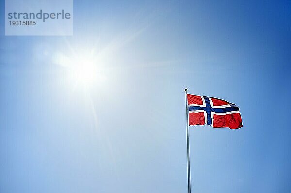 Die Flagge Norwegens vor sonnigem Himmel