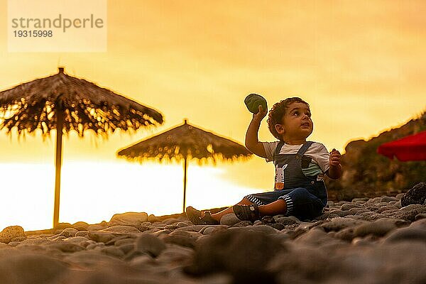 Sonnenuntergang in Ponta do Sol  Madeira  ein Kind spielt mit den Steinen am Strand. Portugal