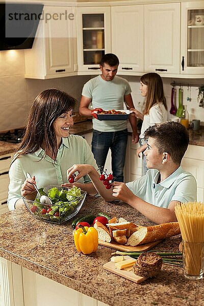 Familie verbringt Zeit in der Küche und bereitet Essen zu