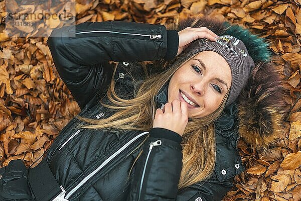 Lifestyle Session  Ein blondes Mädchen lächelt in den Blättern des Otzarreta Waldes im Naturpark von Gorbea. Baskenland