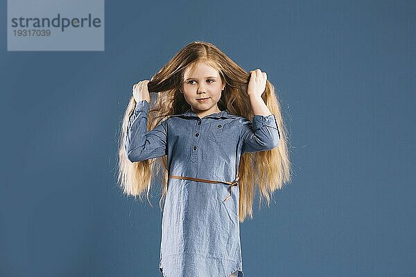 Niedliches Mädchen berührt Haare