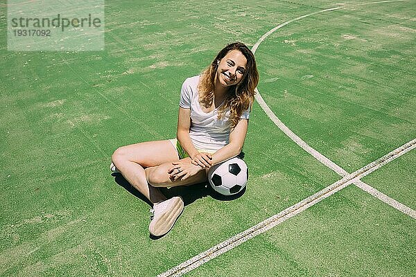 Glücklicher Teenager mit Ball Fußballplatz