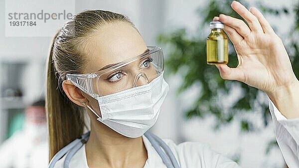 Frontansicht weibliche Forscherin mit medizinischer Maske Impfstoff