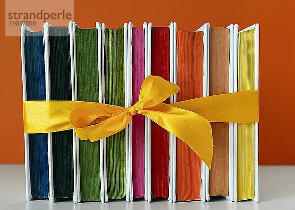 Regenbogen Bücher stapeln mit gelber Schleife