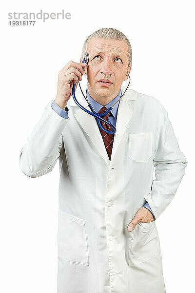 Lustiger reifer Arzt hält Stethoskop auf dem Kopf