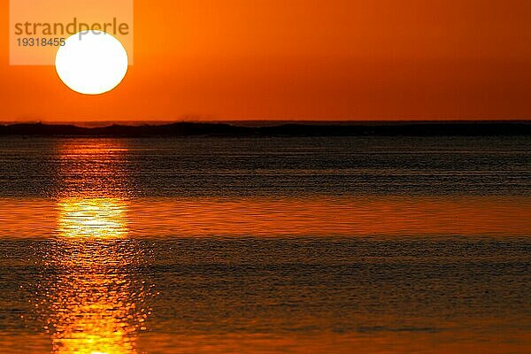 Die untergehende Sonne spiegelt sich im ruhigen Wasser der Lagune vor Le Morne  Mauritius  Afrika