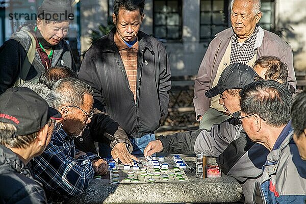 New York  Vereinigte Staaten von Amerika  17. November 2016: Eine Gruppe chinesischer Männer spielt ein Brettspiel im Columbus Park in Chinatown  Nordamerika