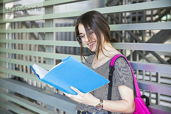 Lachende Frau  die ein Buch an der Wand liest