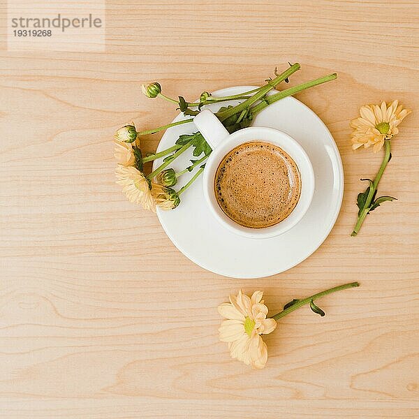 Overhead Ansicht Kaffeetasse Untertasse mit Pfirsich farbigen Blumen hölzernen strukturierten Hintergrund