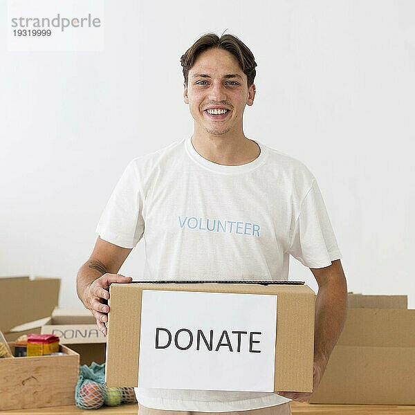 Glücklicher Freiwilliger mit Spendendose