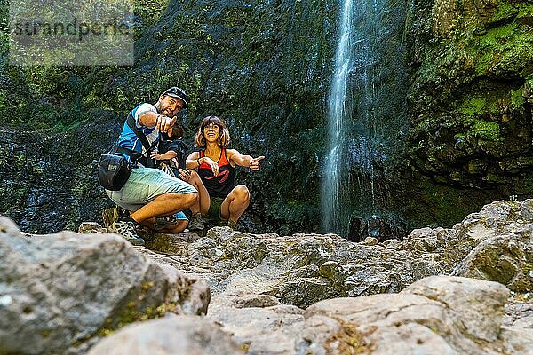 Eine Familie mit ihrem Kind im Sommer am Wasserfall in Levada do Caldeirao Verde  Queimadas  Madeira