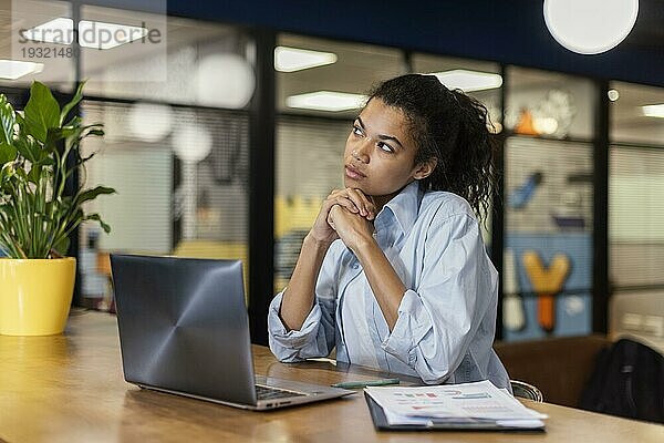 Nachdenkliche Frau im Büro mit Laptop