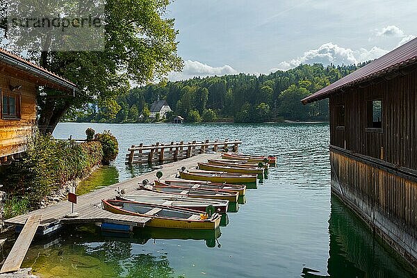 Ruderbootverleih am Steg am Walchensee in Bayern  Deutschland an einem sonnigen Tag mit Bootshaus