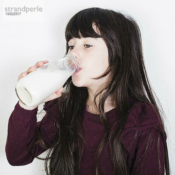 Nahaufnahme süßes Mädchen trinkt Milch aus der Flasche