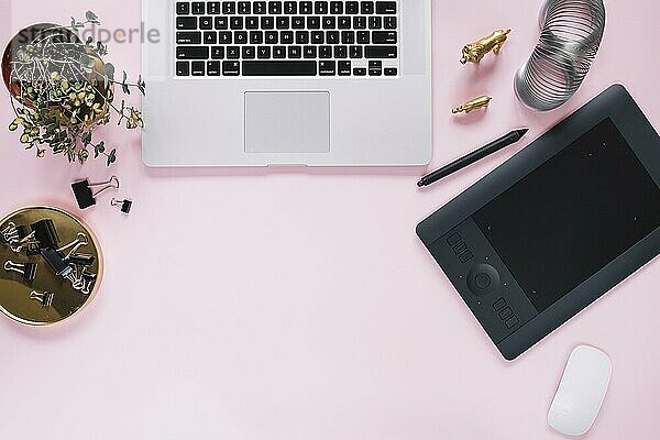 Draufsicht auf einen offenen Laptop mit stationärem rosa Hintergrund