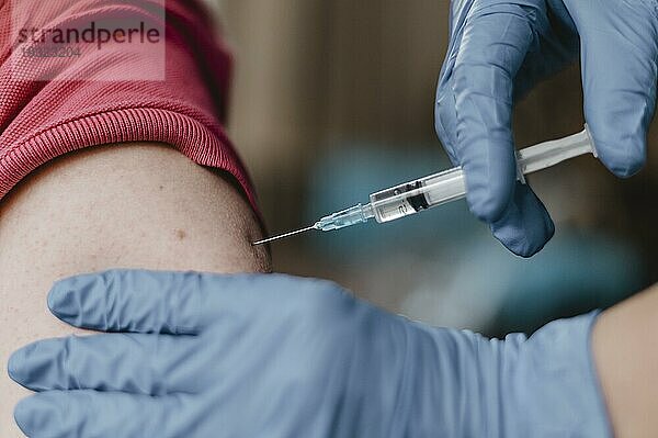 Arzt mit Handschuhen beim Impfen eines Kindes