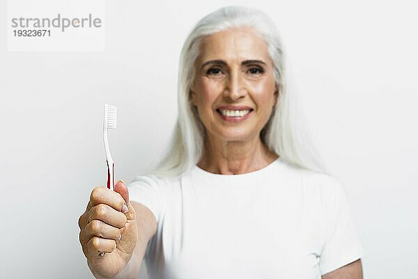 Smiley reife Frau stolz ihre Zahnbürste