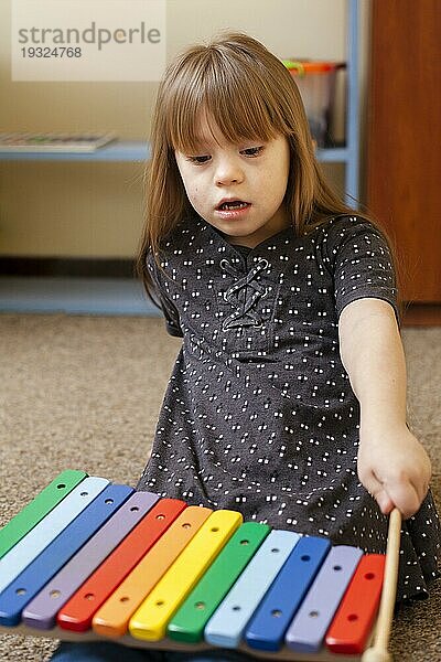 Vorderansicht Mädchen mit Down Syndrom spielt mit Xylophon