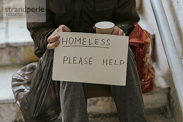 Vorderansicht Obdachloser mit Hilfezeichen Plastiktüte