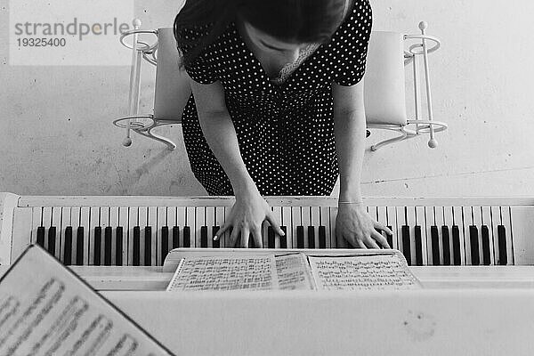 Draufsicht junge Frau spielt Klavier